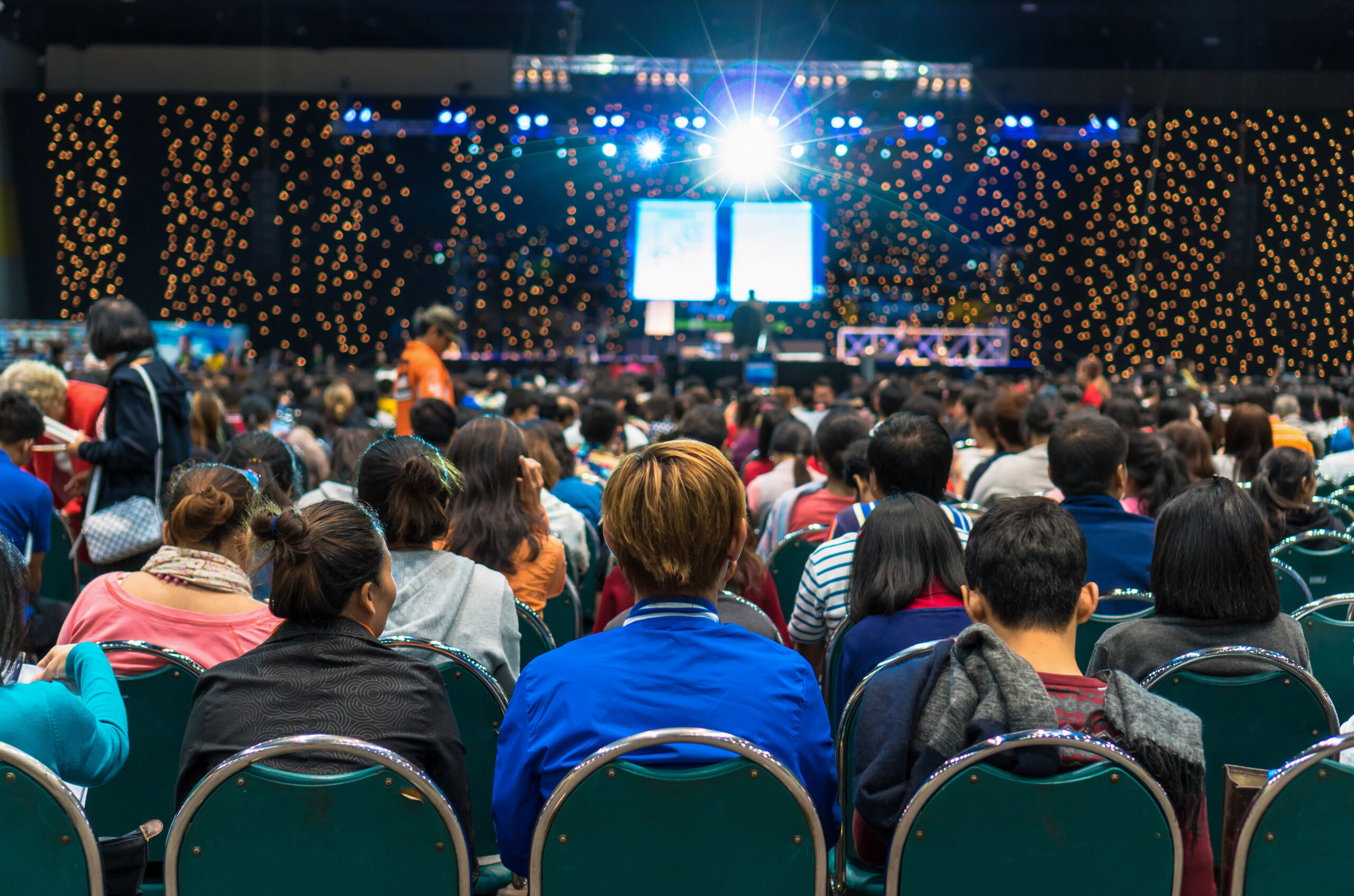 Rear view of Audience in the conference hall or seminar meeting which have Speakers on the stage, business and education about investment concept